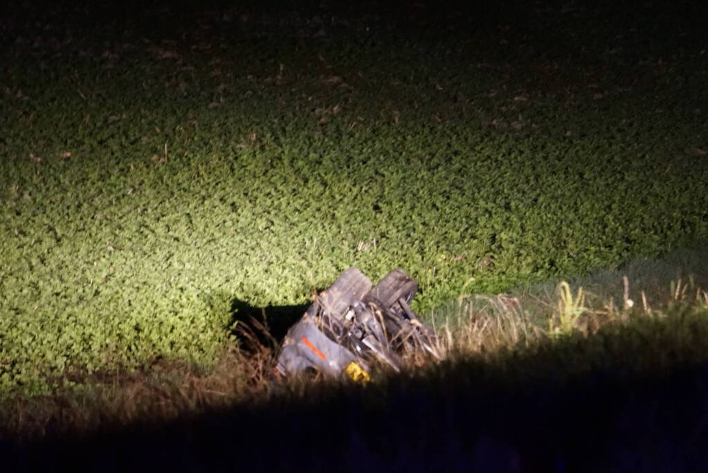 Auto op zijn kop in sloot naast talud