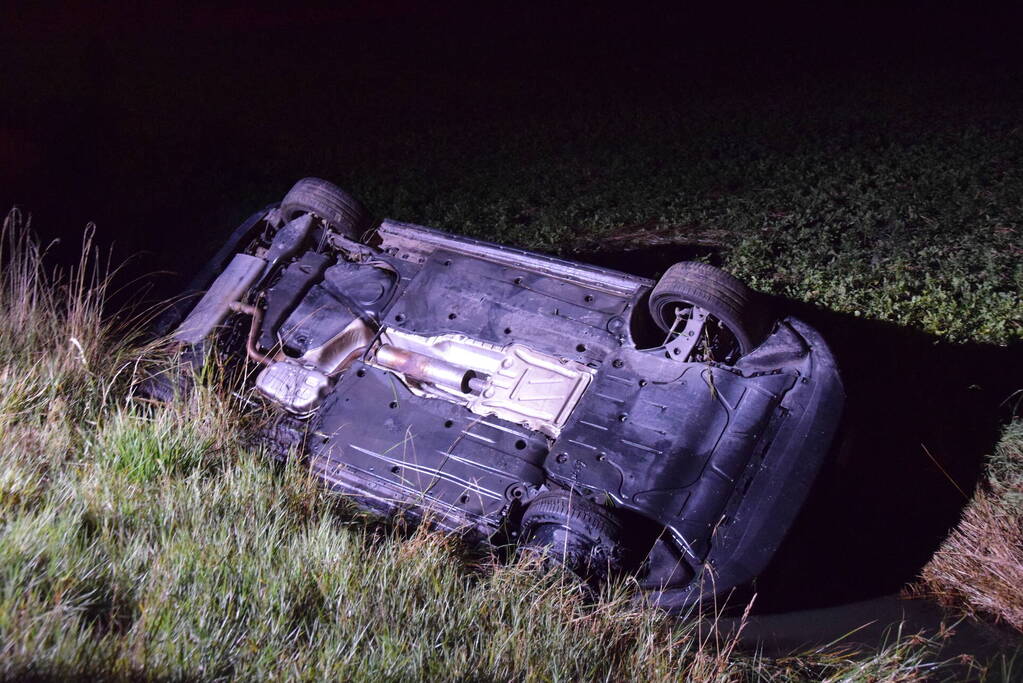 Auto op zijn kop in sloot naast talud
