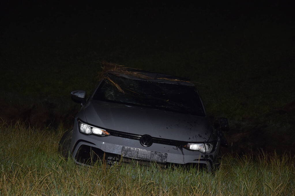 Auto op zijn kop in sloot naast talud