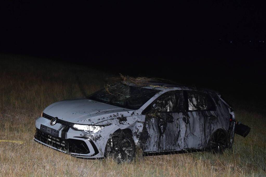 Auto op zijn kop in sloot naast talud