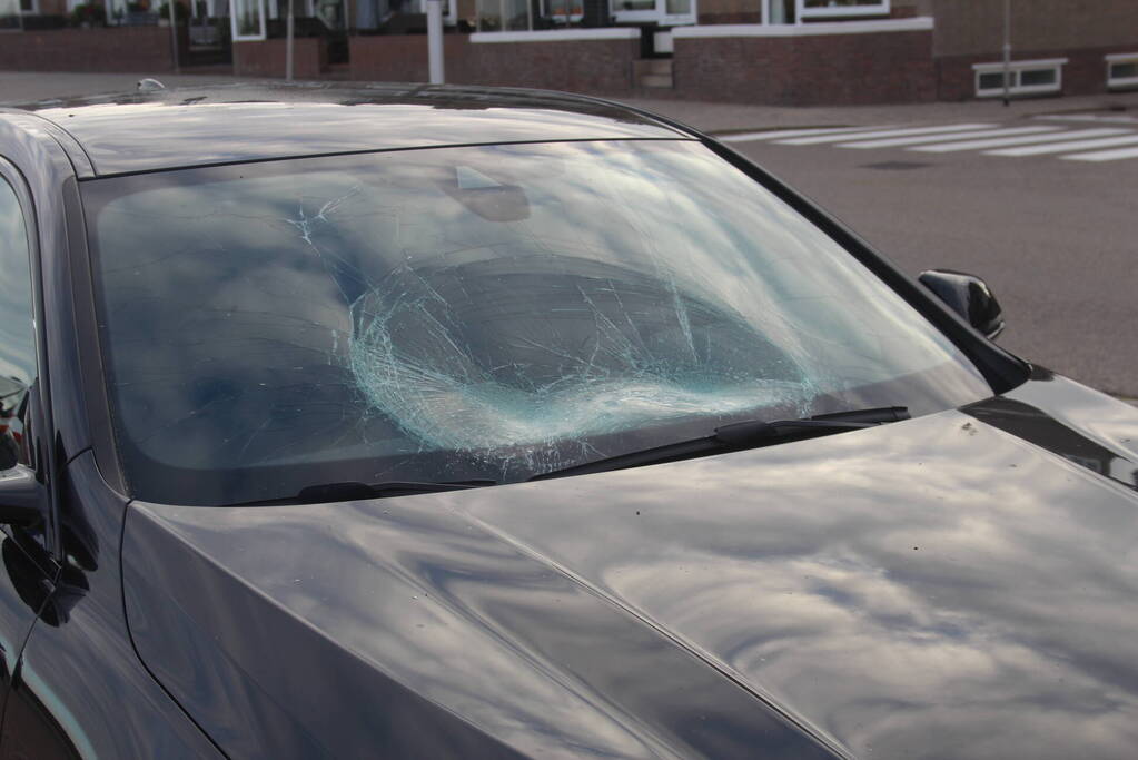 Racefietser belandt op voorruit van auto