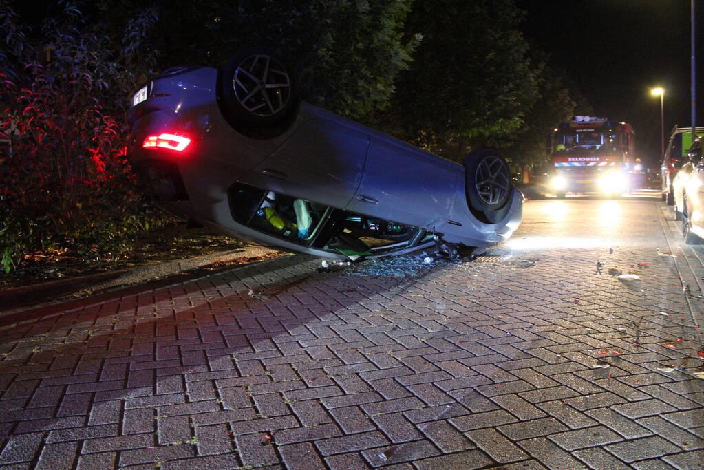 Auto slaat over de kop na botsing tegen stilstaande auto's