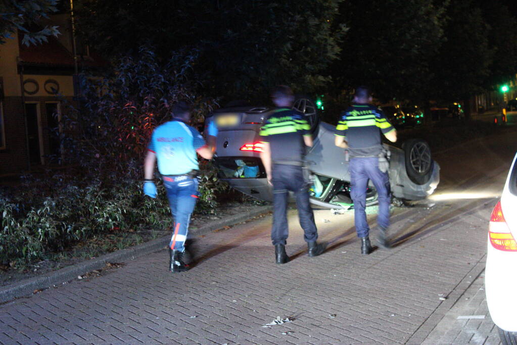 Auto slaat over de kop na botsing tegen stilstaande auto's