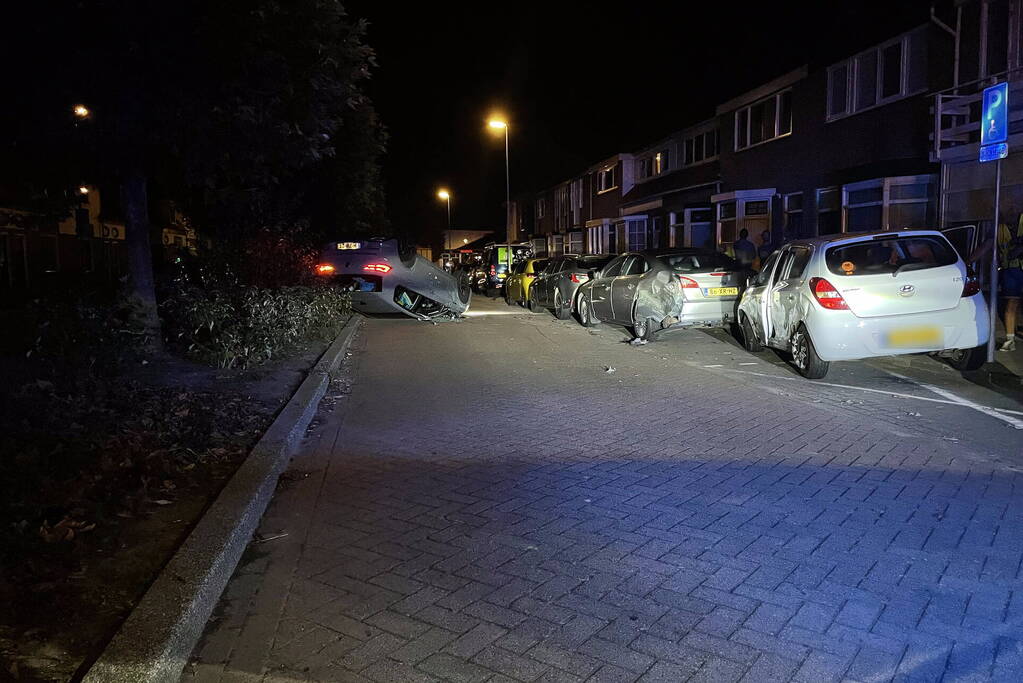 Auto slaat over de kop na botsing tegen stilstaande auto's
