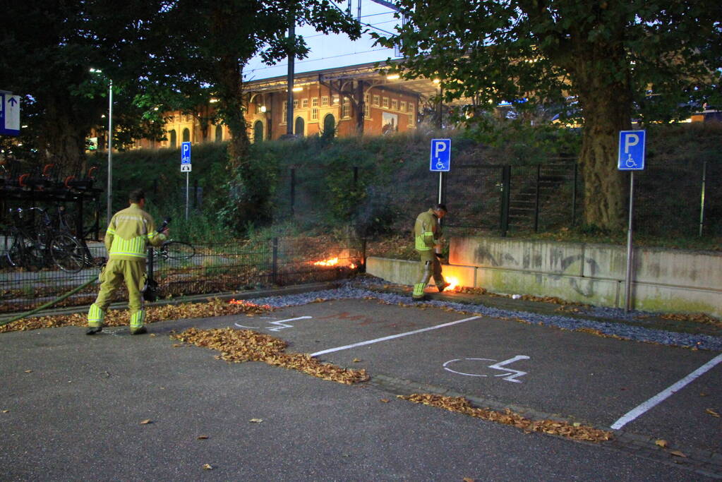 Bladeren vliegen in brand op parkeerterrein