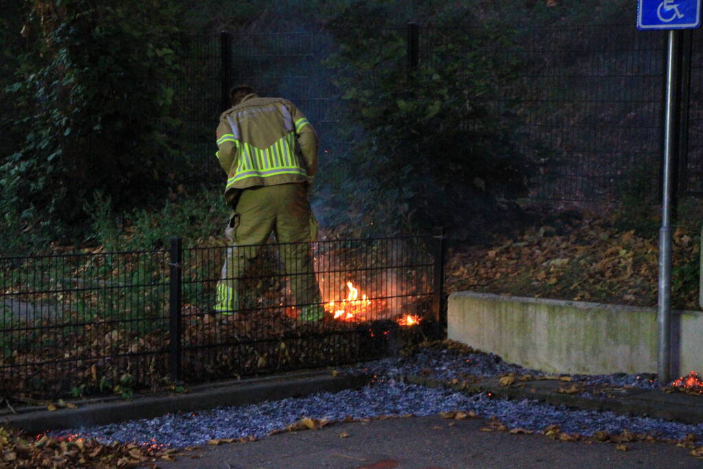 Bladeren vliegen in brand op parkeerterrein