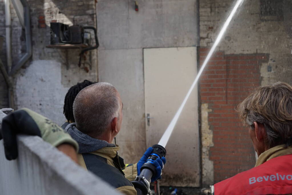 Hoop rommel tegen gevel in brand
