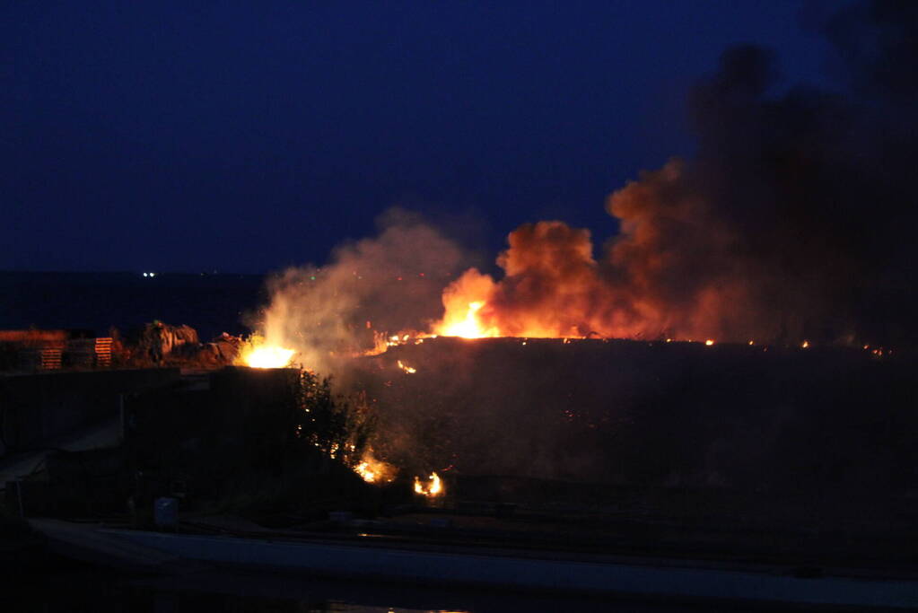 Groot stuk dijk in brand