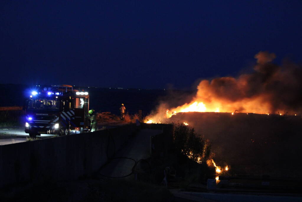 Groot stuk dijk in brand