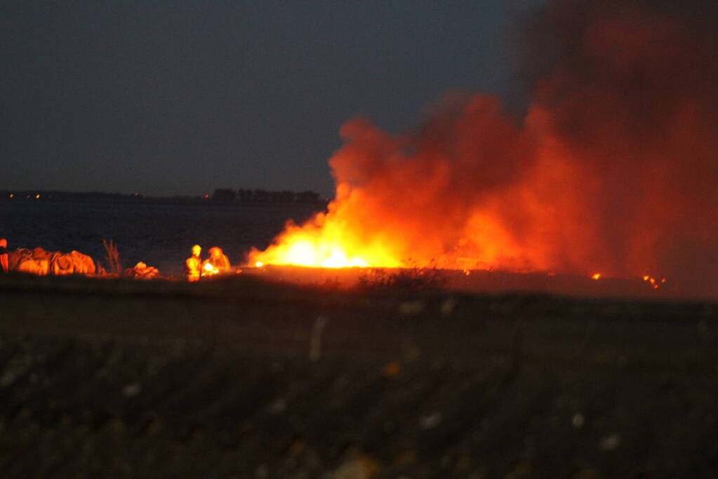 Groot stuk dijk in brand