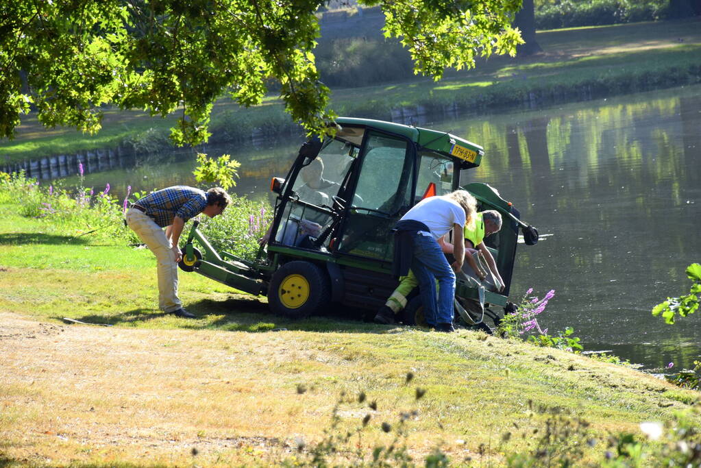 Grasmaaier dreigt in het water te vallen