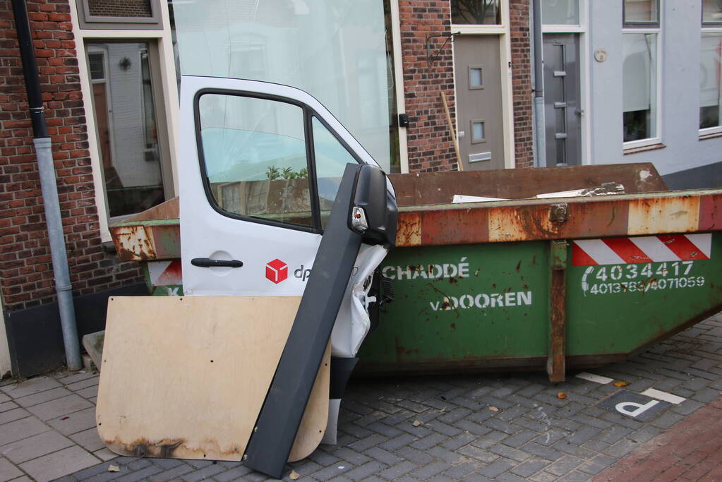 Pakketbezorger botst tegen bouwcontainer en knalt tegen woning