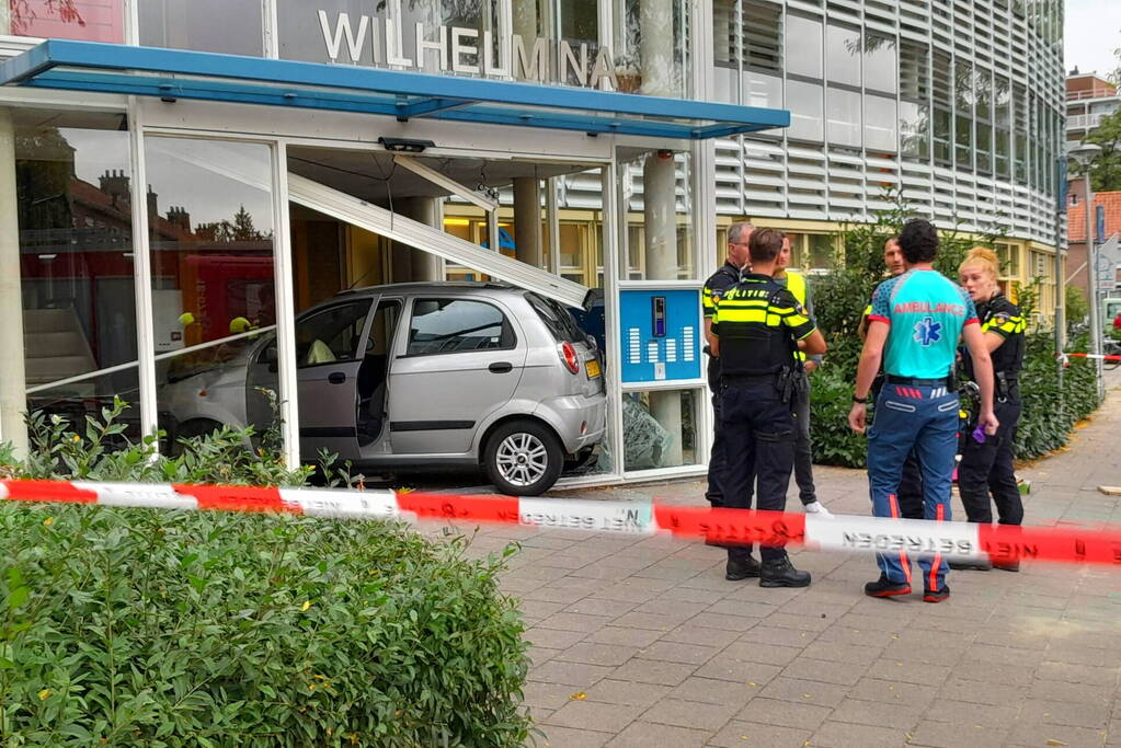 Bestuurster ramt met auto entree flatgebouw