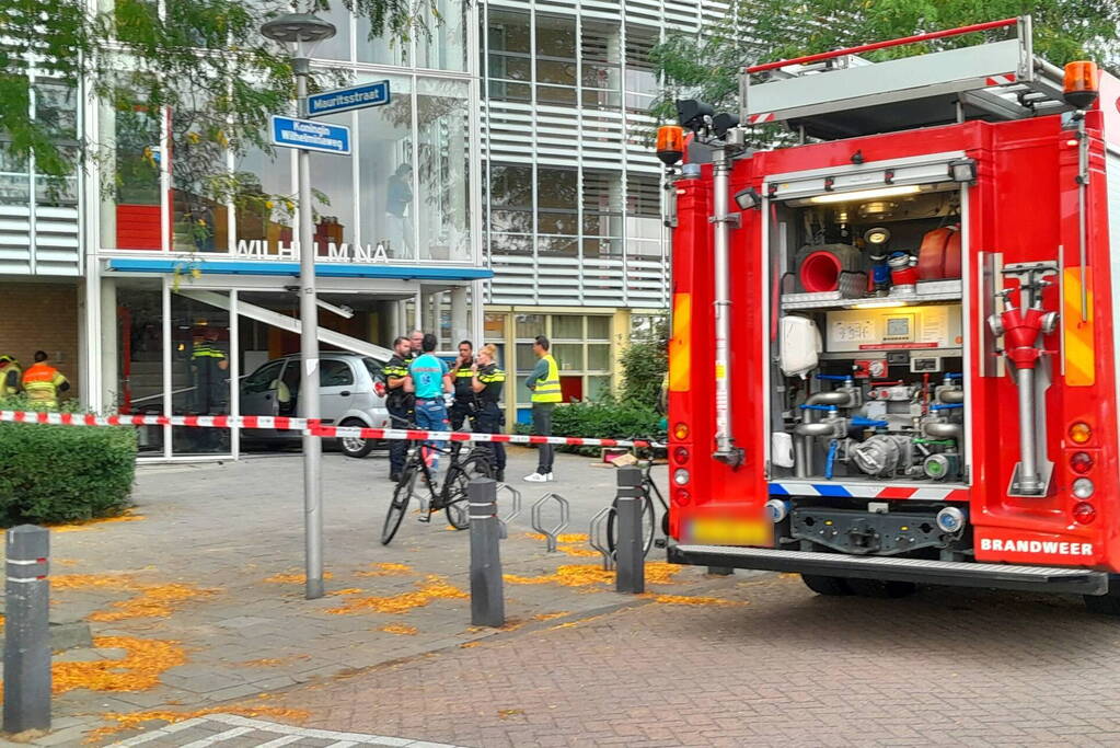 Bestuurster ramt met auto entree flatgebouw