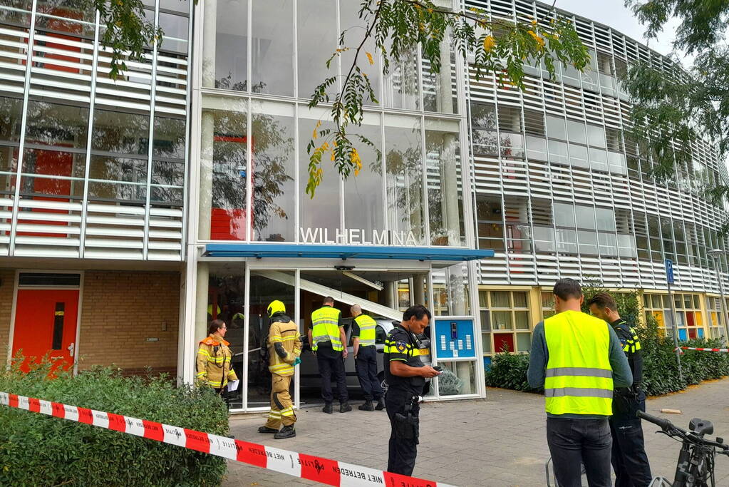 Bestuurster ramt met auto entree flatgebouw