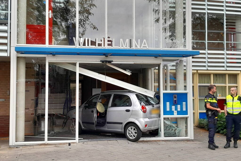 Bestuurster ramt met auto entree flatgebouw