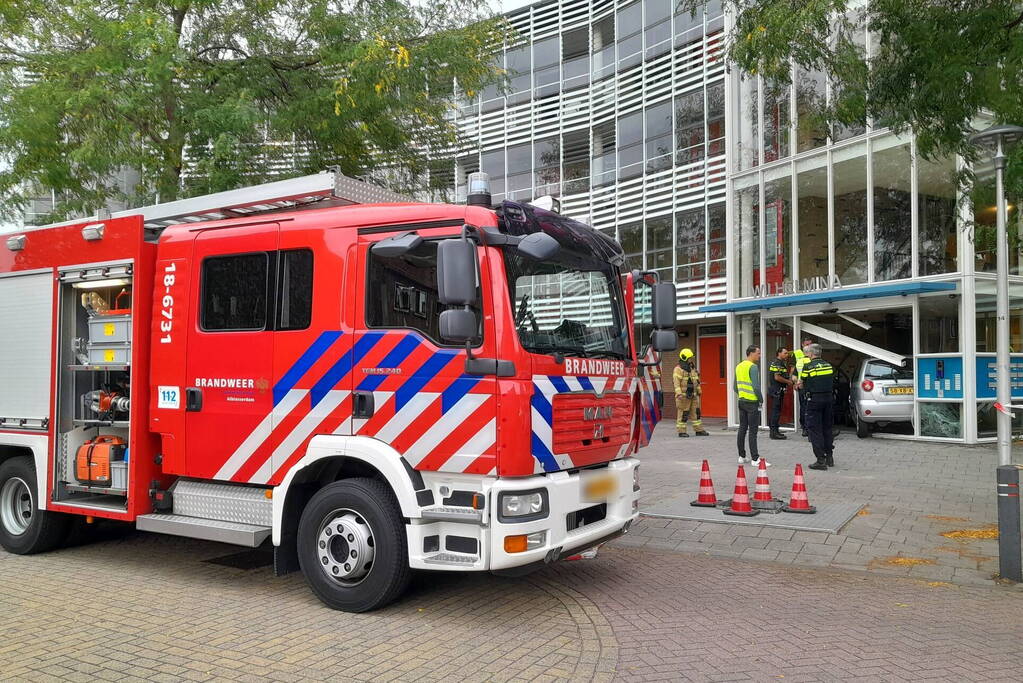 Bestuurster ramt met auto entree flatgebouw