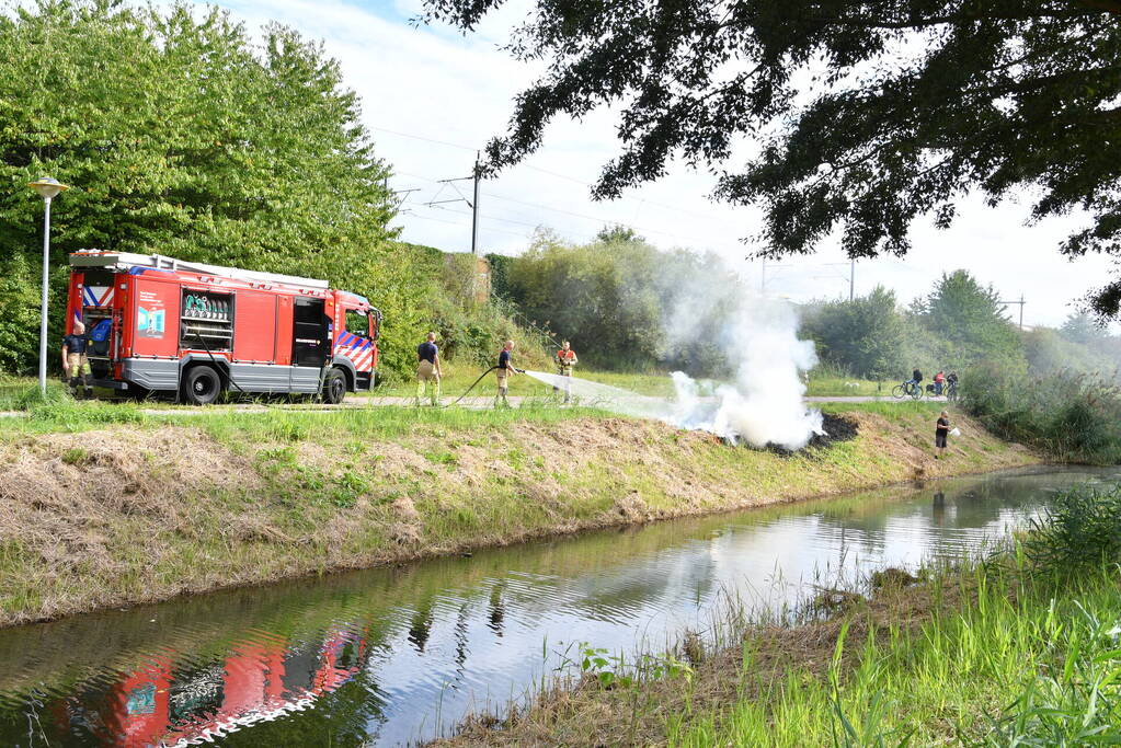 Man helpt brand blussen met emmers water