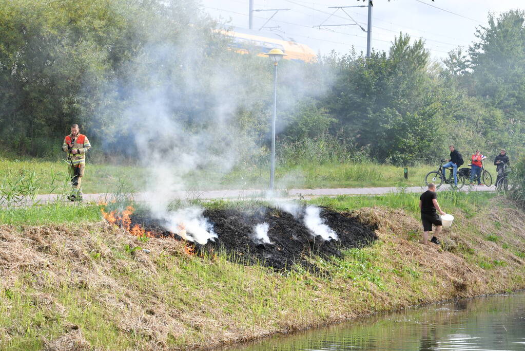 Man helpt brand blussen met emmers water