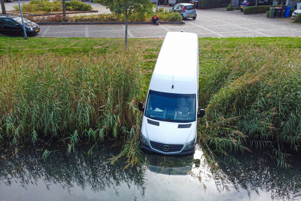 Bestelbus van pakketbezorger rolt water in