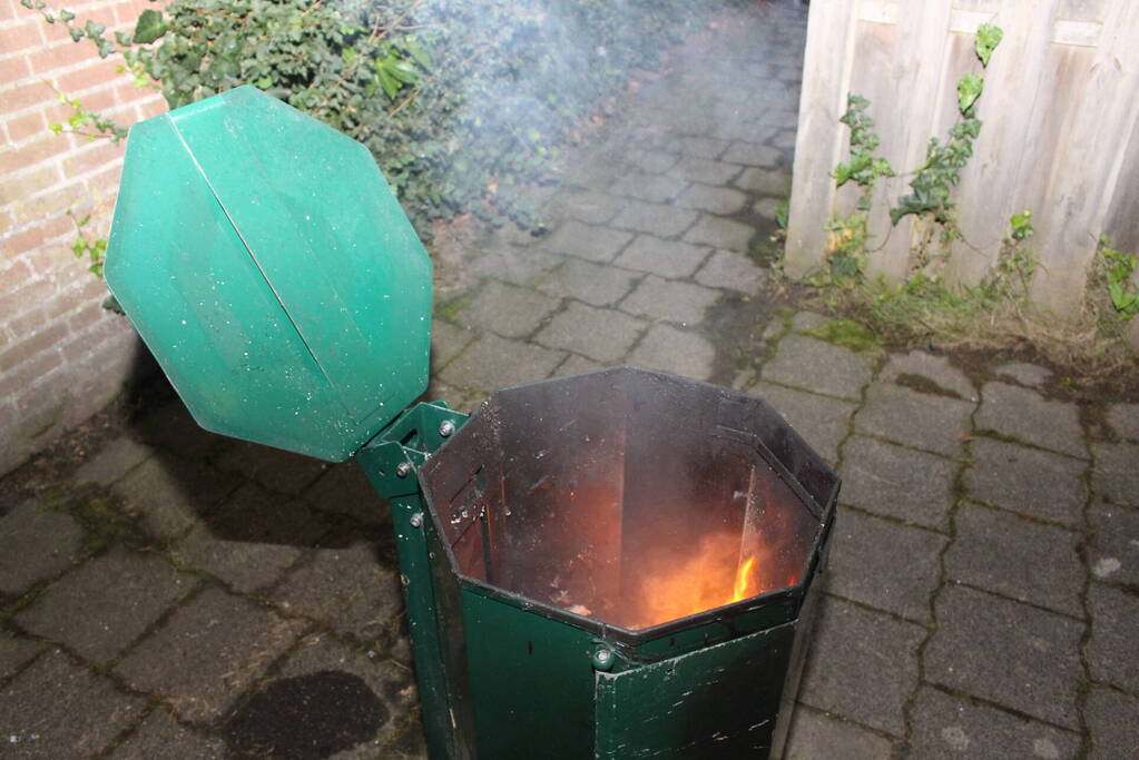 Brandweer blust brand in prullenbak