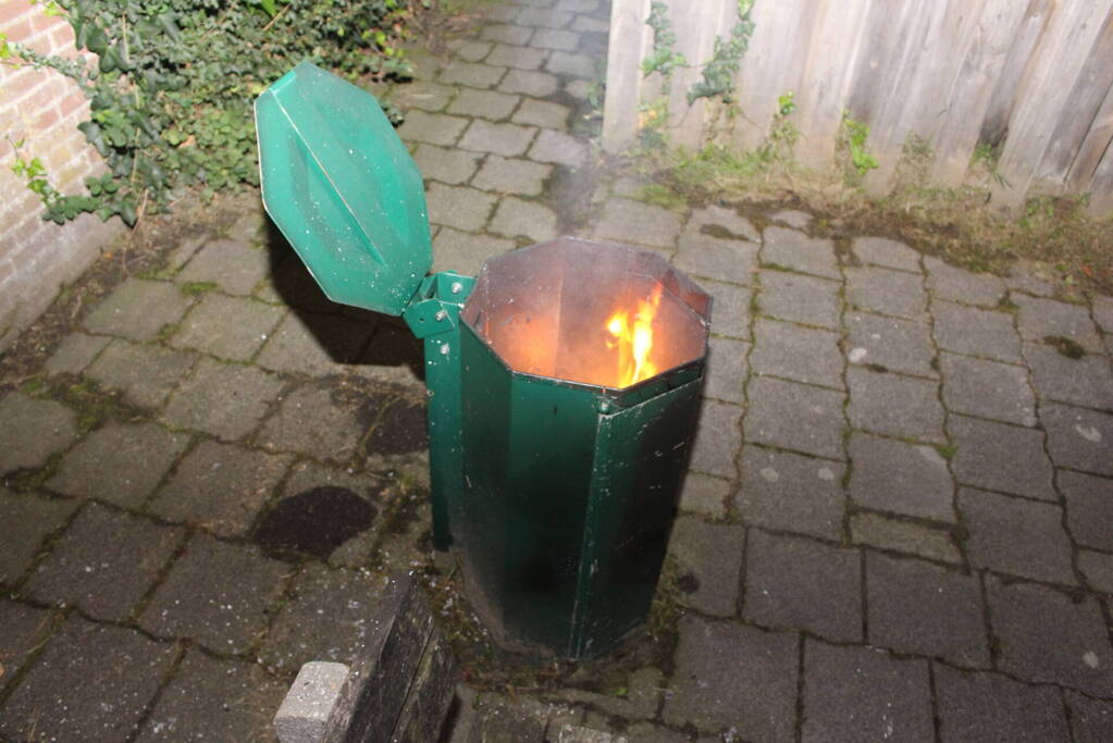 Brandweer blust brand in prullenbak