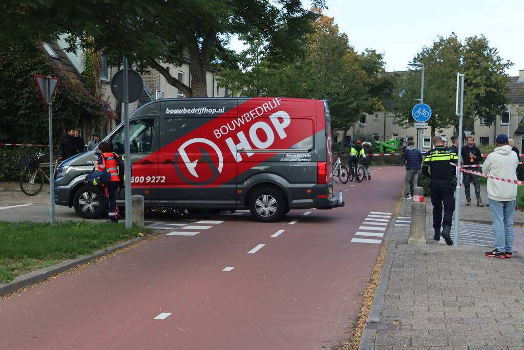 Persoon belandt onder bestelbus