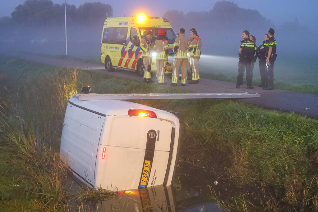 Bestelbus belandt op zijn kant in sloot