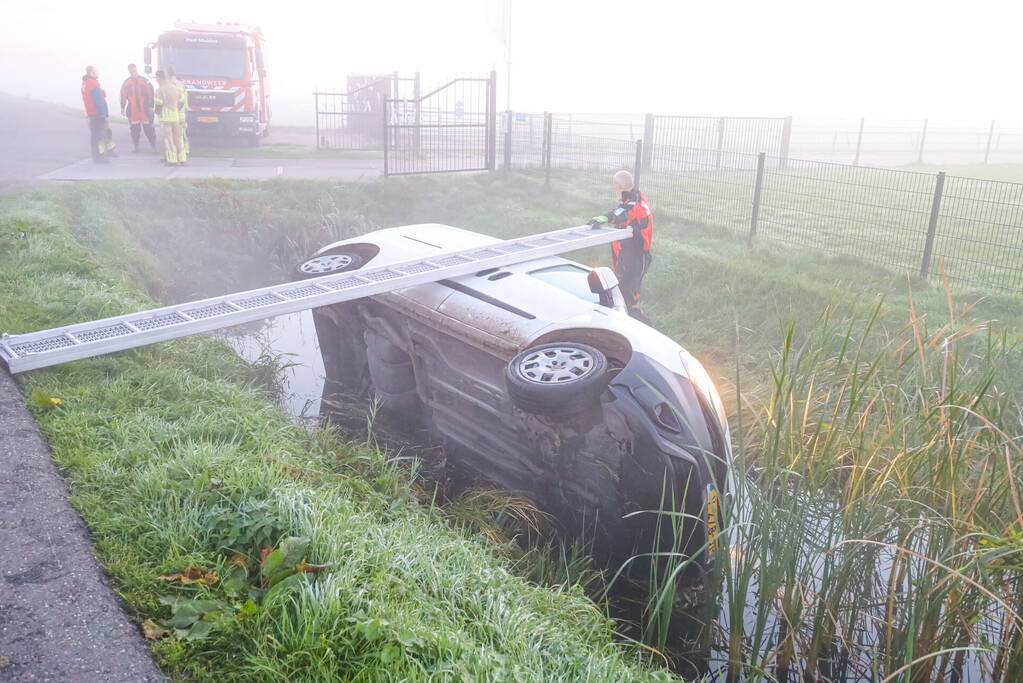 Bestelbus belandt op zijn kant in sloot