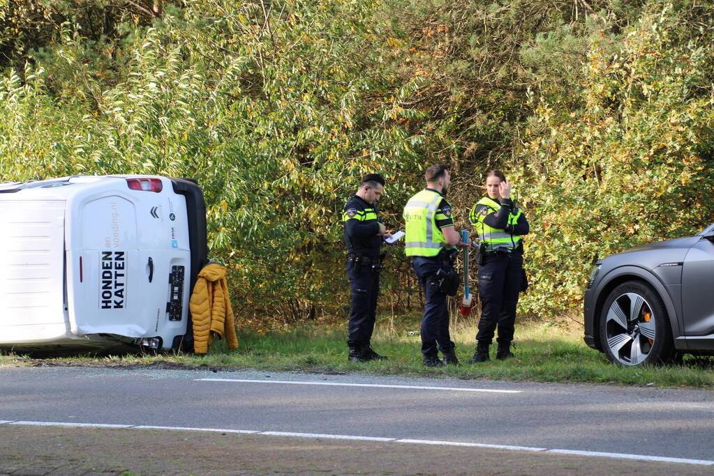 Bestelbus op zijn kant na ongeval