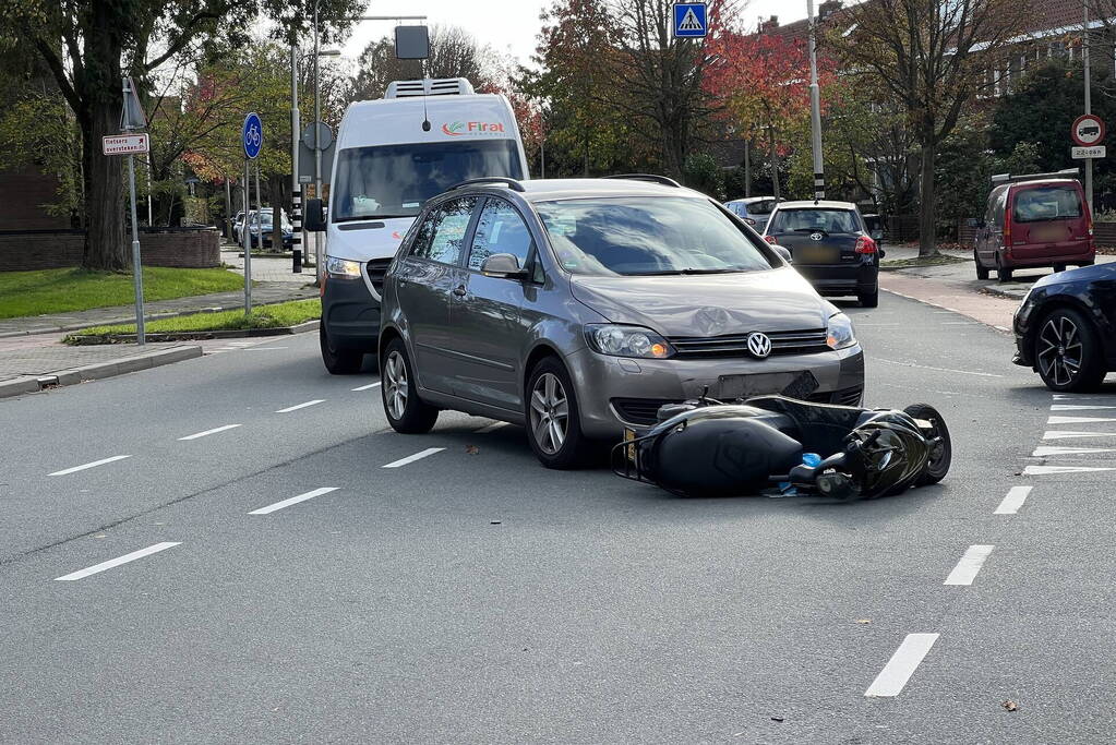 Personenauto ziet scooterrijder over het hoofd