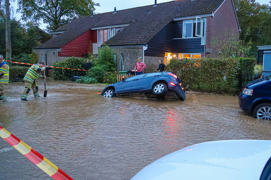 Auto zakt in sinkhole door gesprongen hoofdwaterleiding