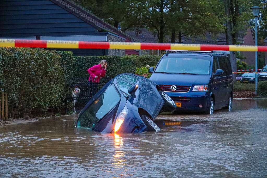 Auto zakt in sinkhole door gesprongen hoofdwaterleiding