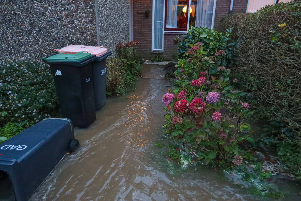 Auto zakt in sinkhole door gesprongen hoofdwaterleiding