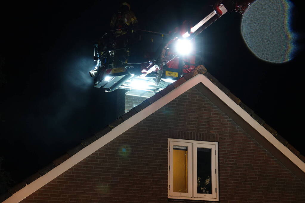 Brandweer blust brand in schoorsteen