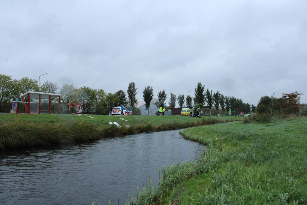 Automobilist ramt bushokje en boom