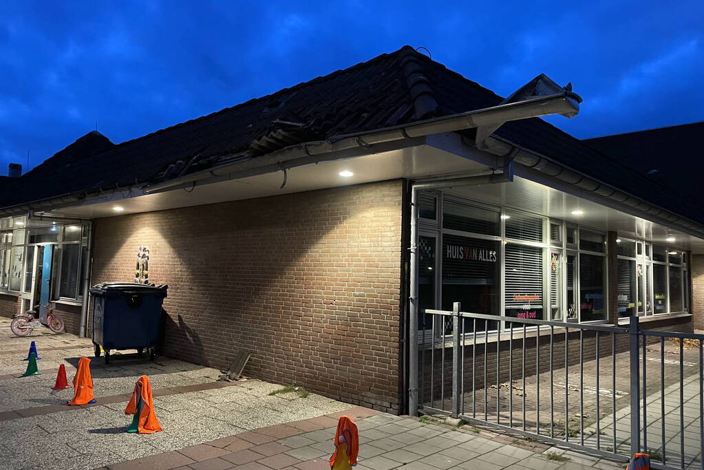 Vrachtwagen rijdt tegen dak van gebouw