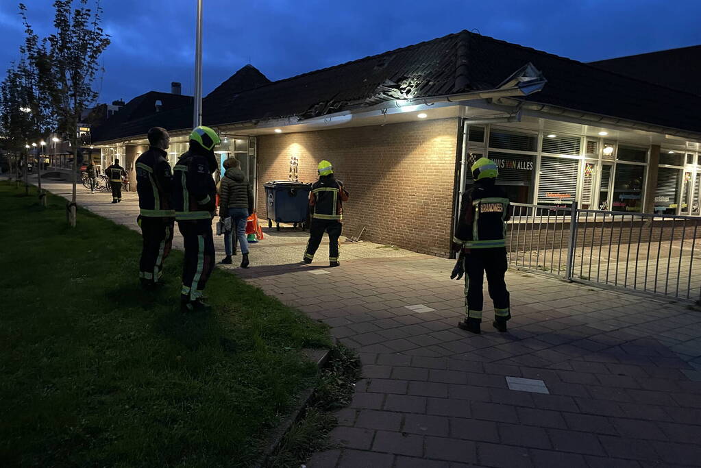 Vrachtwagen rijdt tegen dak van gebouw