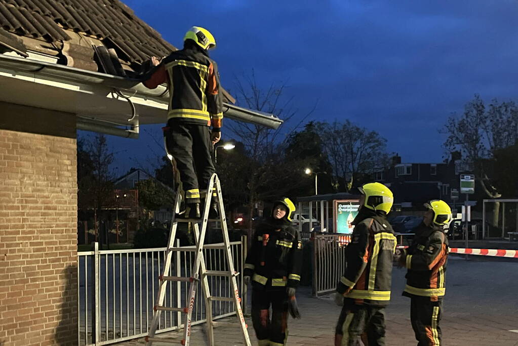 Vrachtwagen rijdt tegen dak van gebouw