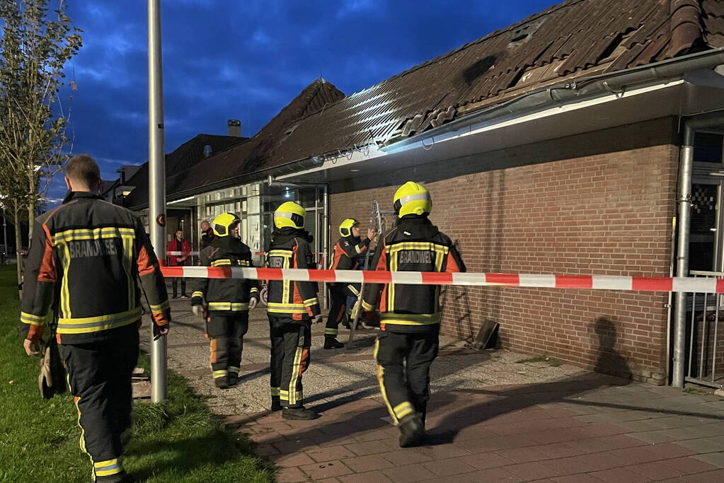 Vrachtwagen rijdt tegen dak van gebouw