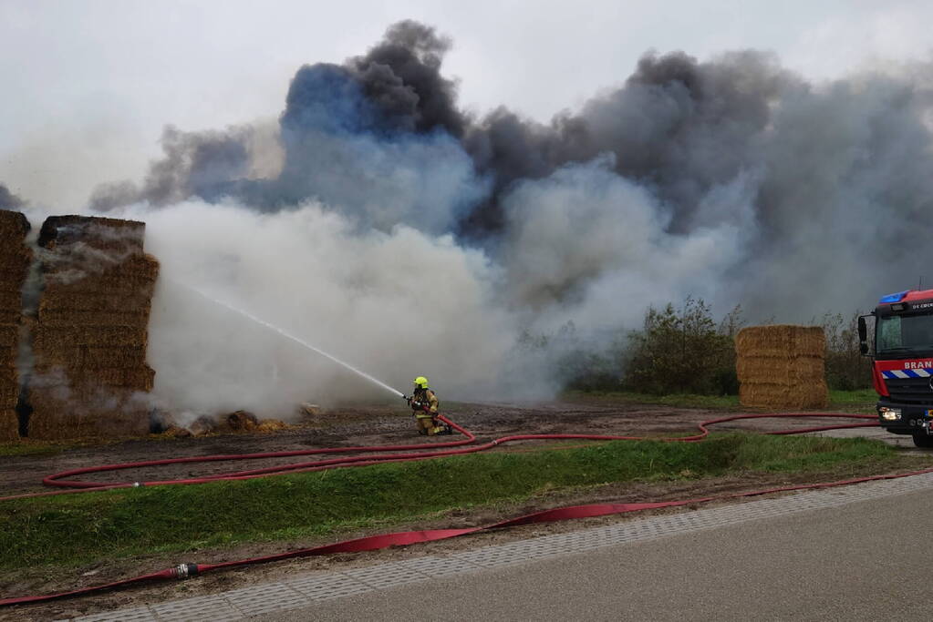 Grote stapel hooi vliegt in brand