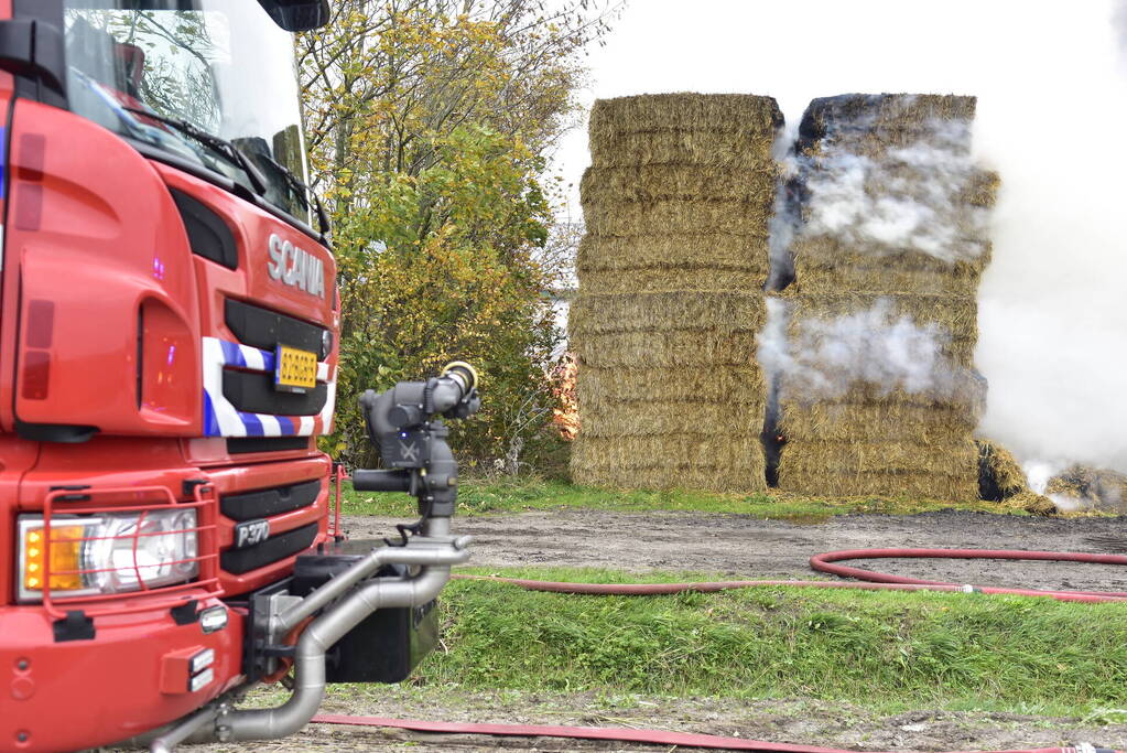 Grote stapel hooi vliegt in brand