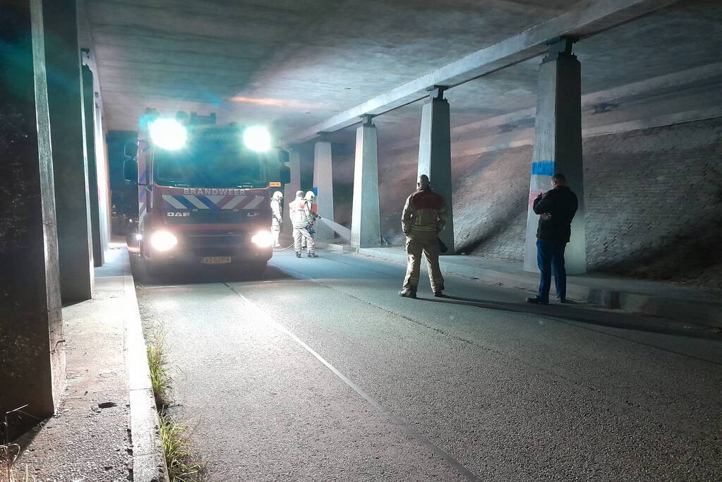 Brandweer blust afvalbrand onder viaduct