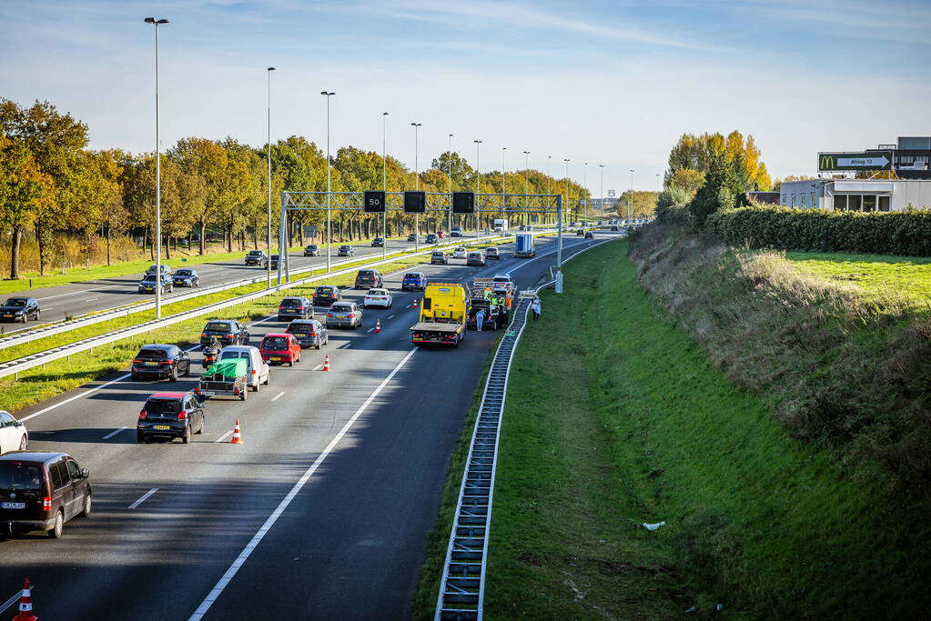 Automobilist verliest overbeladen aanhangwagen met pallets en crasht