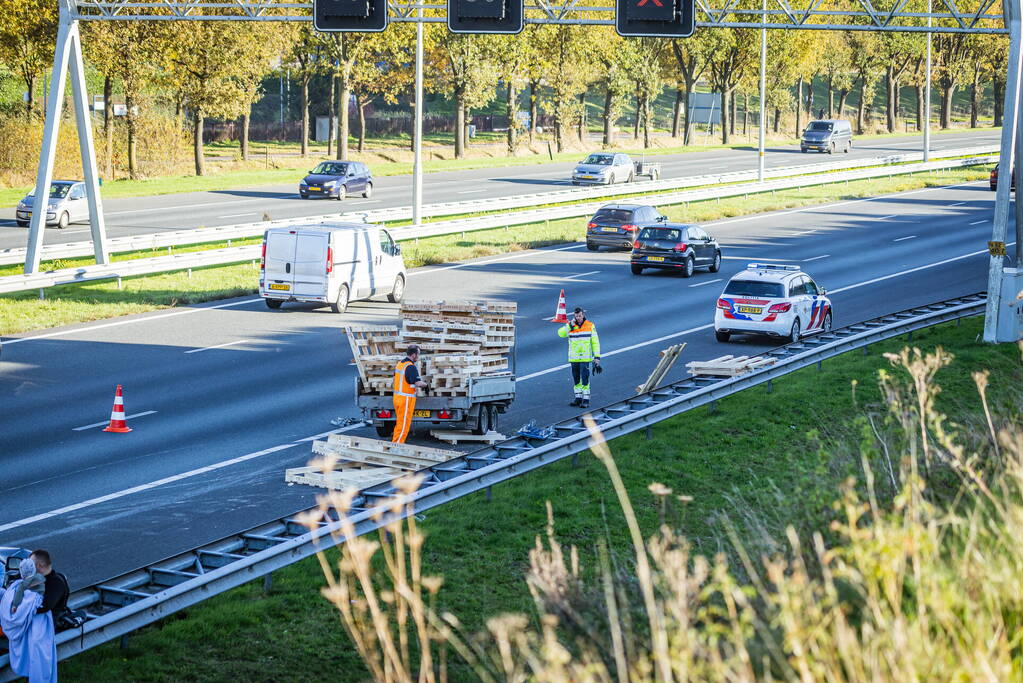 Automobilist verliest overbeladen aanhangwagen met pallets en crasht