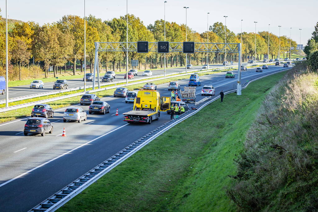 Automobilist verliest overbeladen aanhangwagen met pallets en crasht