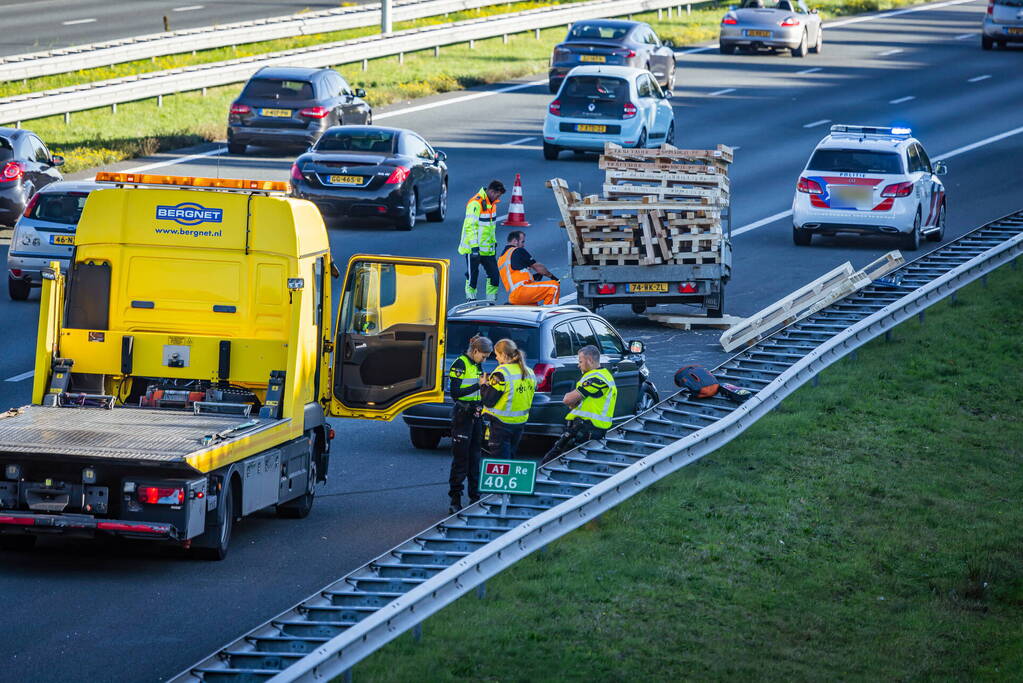 Automobilist verliest overbeladen aanhangwagen met pallets en crasht