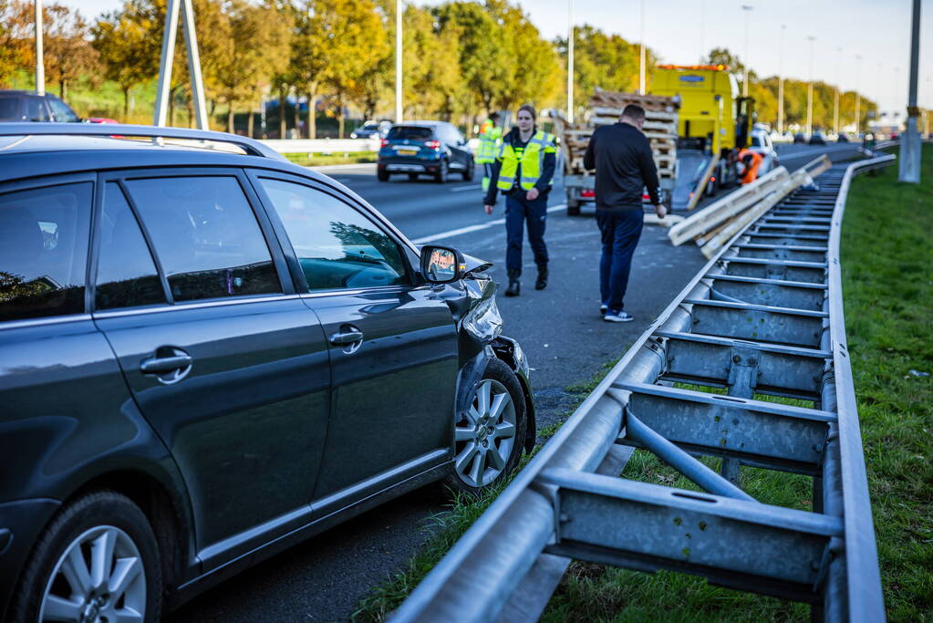 Automobilist verliest overbeladen aanhangwagen met pallets en crasht