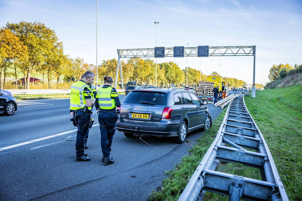 Automobilist verliest overbeladen aanhangwagen met pallets en crasht