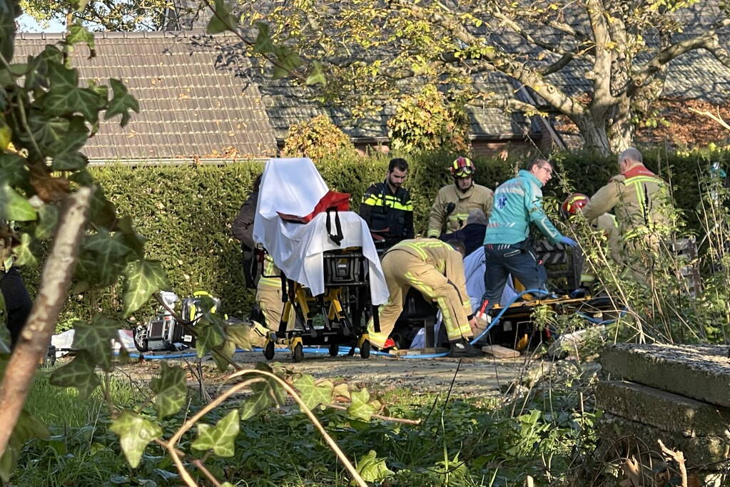 Man gewond na beknelling onder graafmachine